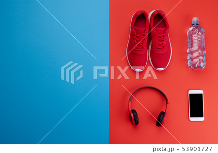 A studio shot of running shoes and other sport equipment on color background. A studio shot of running shoes and other sport equipment on color background. 53901727