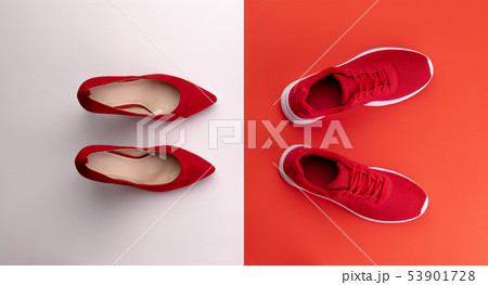 A studio shot of pair of running vs high heel shoes on color background. Flat lay. 53901728