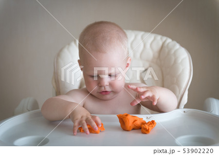Children creativity. the baby is trying to sculpt from clay. Cute little boy mould from plasticine Children creativity. the baby is trying to sculpt from clay. Cute little boy mould from plasticine 53902220