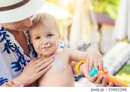 Mother applying sunscreen protection creme on cute little toddler boy face. Mom using sunblocking 53902266