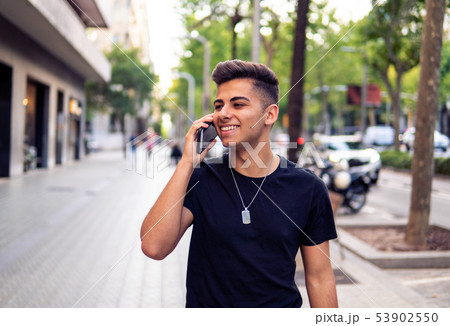 man on the street talking on a cell phone man on the street talking on a cell phone 53902550