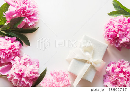 Bouquet of pink peony in vase with gift on white. 53902717