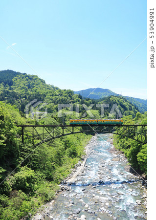 新緑の渓谷と橋を渡る電車 53904991