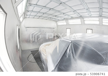 Garage painting car service. Vehicle is covered with protective paper. Repairing car body work after 53906741