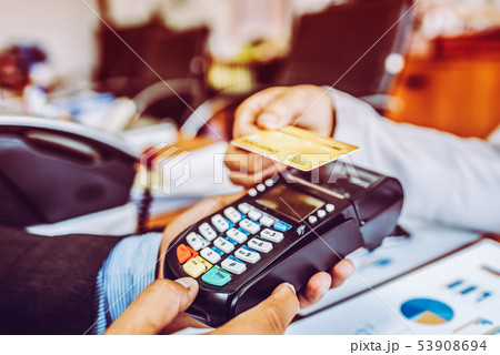Hand of business man customer paying with NFC Hand of business man customer paying with NFC 53908694
