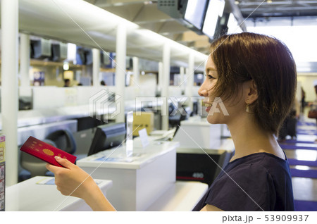 航空会社カウンターで搭乗手続きをする女性 53909937