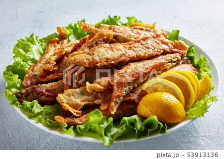 Fried in batter capelins on a plate, close-up 53913136