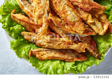 Fried small capelins on a white plate 53913142