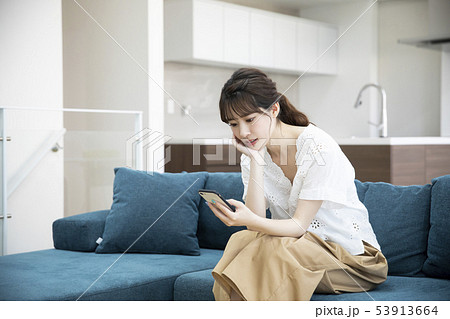 ソファーに座る若い女性・スマートフォン 53913664