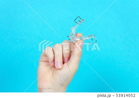 child's hand with orthodontic appliance on blue 53914052