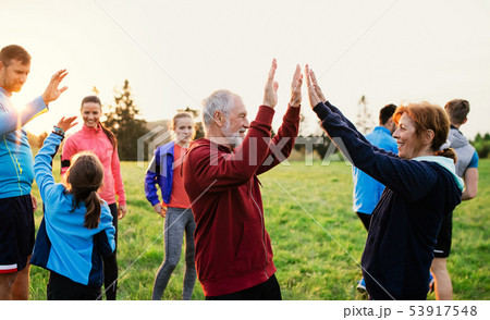 Large group of fit and active people resting after doing exercise in nature. Large group of fit and active people resting after doing exercise in nature. 53917548