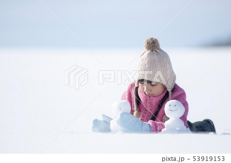 雪原で雪だるまを作る女の子 53919153
