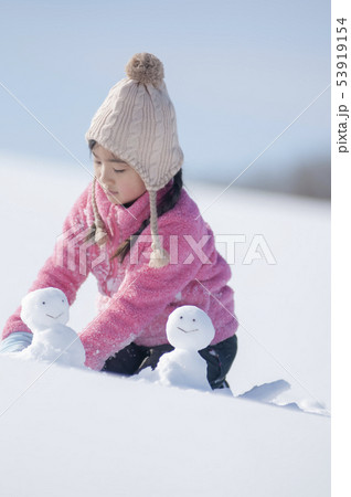 雪原で雪だるまを作る女の子 雪原で雪だるまを作る女の子 53919154