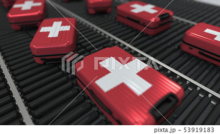 Many travel suitcases featuring flag of Switzerland on roller conveyer. Swiss tourism conceptual 3D 53919183