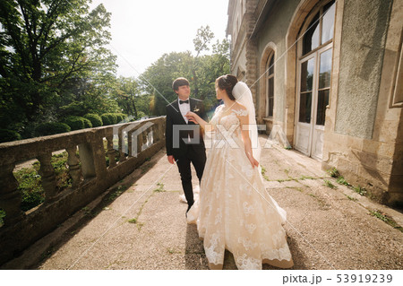 Bride leads groom in the castle. Happy newlyweds walking 53919239