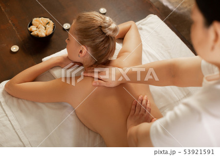Calm woman with fit body lying on a covered bed in equipped cabinet 53921591
