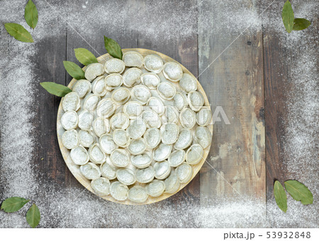 Meat dumplings - russian pelmeni on wooden background Meat dumplings - russian pelmeni on wooden background 53932848