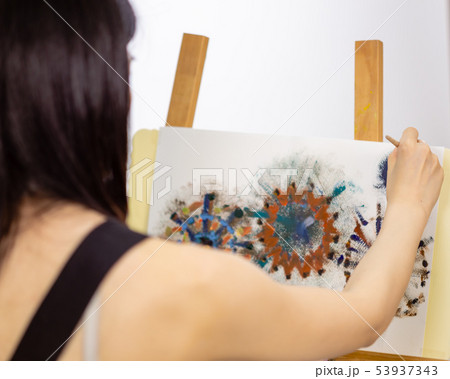 Artist painting on an easel 53937343