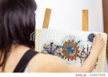 Artist painting on an easel 53937344