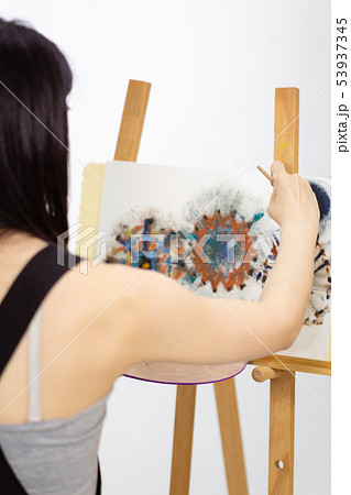 Artist painting on an easel 53937345