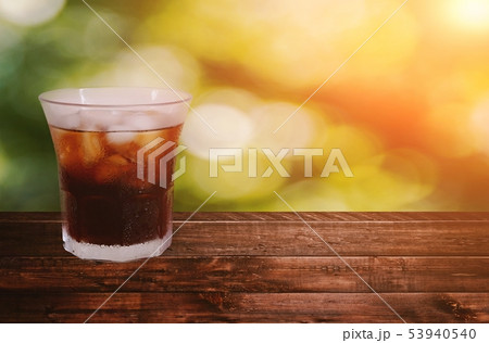 A ice americano coffee on wood floor A ice americano coffee on wood floor 53940540