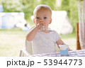 Portrait of a baby eating with a stained face. 53944773