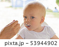 Mother or father feeding cute baby boy with cream 53944902