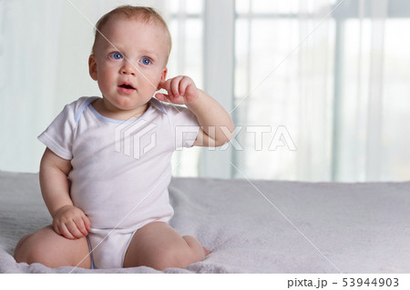Playful little boy on the bed against window background Playful little boy on the bed against window background 53944903