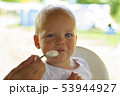 Mother or father feeding cute baby boy with cream 53944927