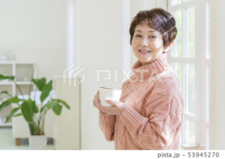 マグカップを持って振り返るシニア女性 53945270