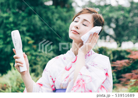 ハンディ扇風機を使う浴衣の女性 53951689