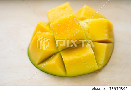 Ripe juicy yellow exotic mango cut into cubes on wooden background. Tropical delicacy full of Ripe juicy yellow exotic mango cut into cubes on wooden background. Tropical delicacy full of 53956395