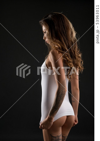 Slim tattooed girl in white t-shirt rearview Slim tattooed girl in white t-shirt rearview 53963011