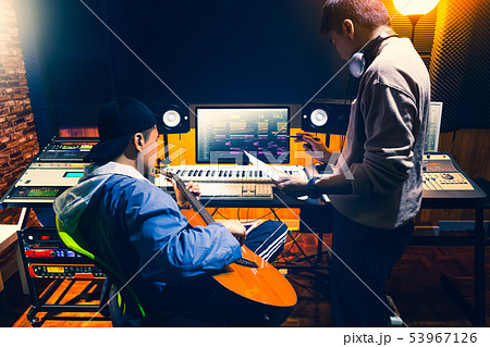 music producer working with guitarist in studio 53967126