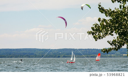Kitesurfer, windsurfer and small sailboat 53968821