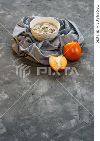 Oatmeal with Persimmon on a Gray Rough Surface Oatmeal with Persimmon on a Gray Rough Surface 53969591