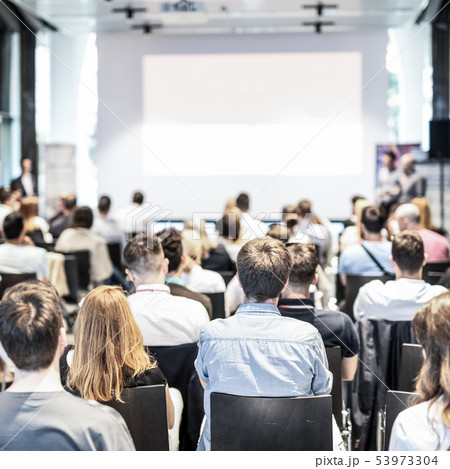 Audience at business conference event looking at presentation on white screen. Copy space. Audience at business conference event looking at presentation on white screen. Copy space. 53973304