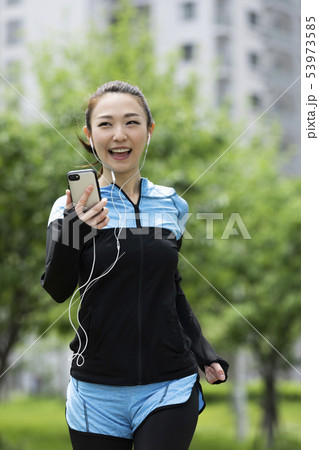 音楽を聴きながら走る女性 53973585