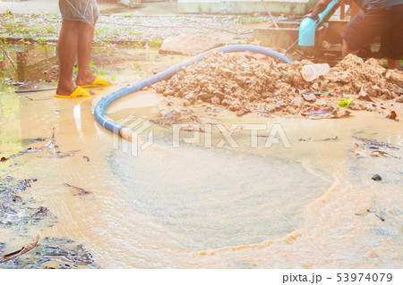broken pipe in hole with water motion at roadside 53974079