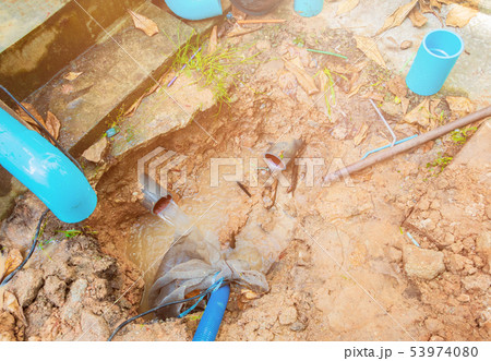 broken pipe in hole with water motion at roadside 53974080