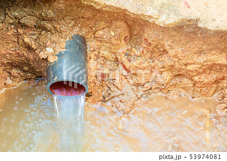 broken pipe in hole with water motion at roadside 53974081