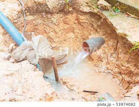 broken pipe in hole with water motion at roadside broken pipe in hole with water motion at roadside 53974082