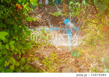 broken pipe in hole with water motion at roadside 53974084