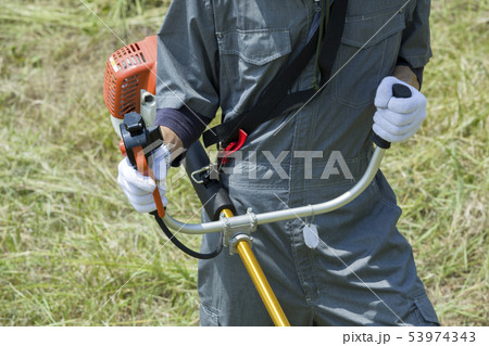 草刈り、除草イメージ　草刈りをする男性手元 53974343