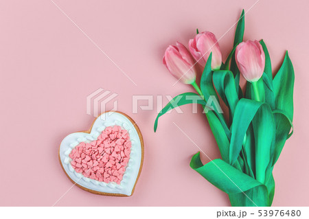 Heart shaped cookie and tulips on pink 53976480