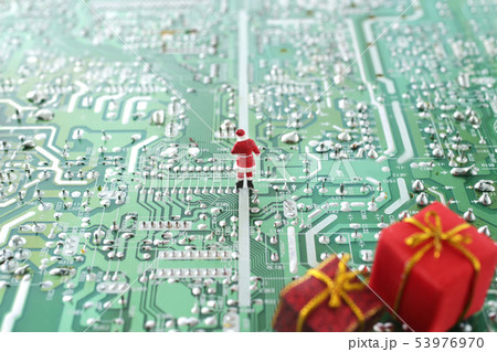 パソコンの基盤の上でクリスマスプレゼントを配るサンタクロース パソコンの基盤の上でクリスマスプレゼントを配るサンタクロース 53976970