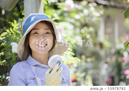 ガーデニング中にミニ扇風機を使う女性 53978782