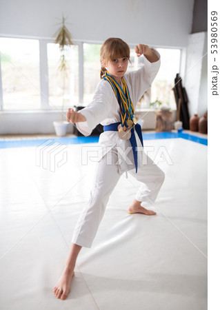 Active sportive girl wearing medals showing her fists Active sportive girl wearing medals showing her fists 53980569