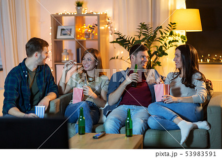 friends with beer and popcorn watching tv at home 53983591
