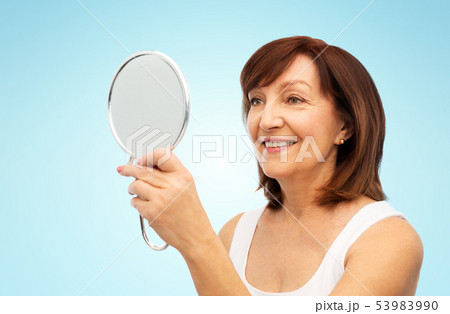 portrait of smiling senior woman with mirror portrait of smiling senior woman with mirror 53983990